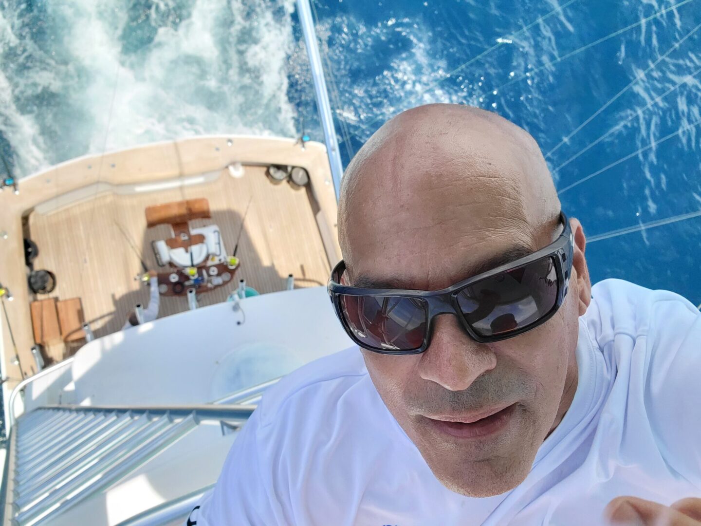 a man taking a selfie from above a yacht